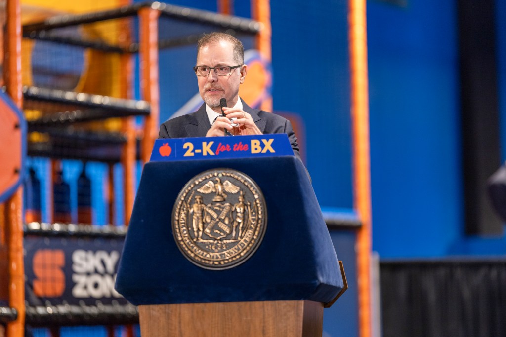 NYC Comptroller Mark Levine speaks at a podium with the Seal of the City of New York.