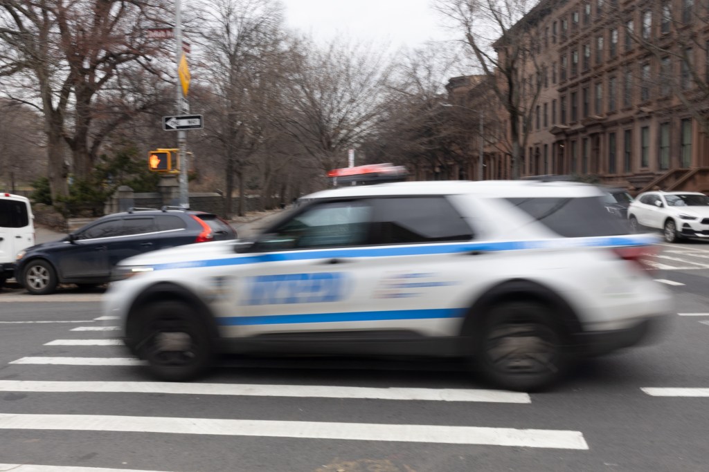 NYPD officers speed down Dekalb Avenue in Brooklyn,