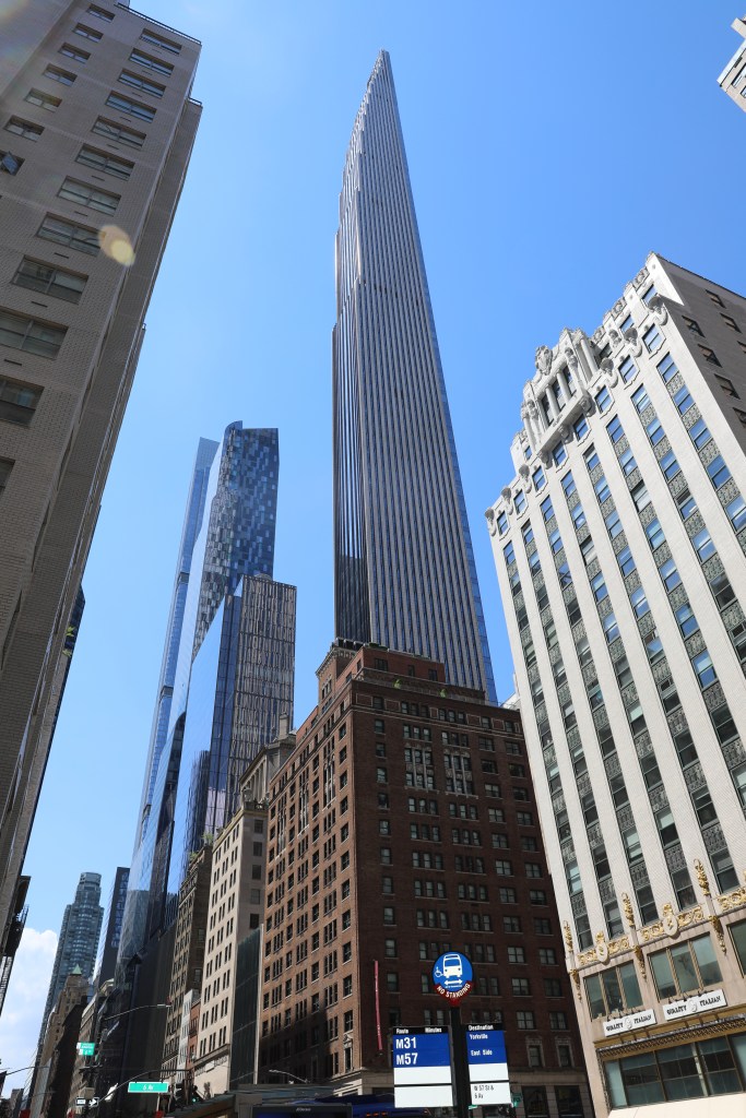 The sky line of 57th street and 5th ave features buildings over a thousand feet tall. The new glass buildings tower over the older stone buildings.