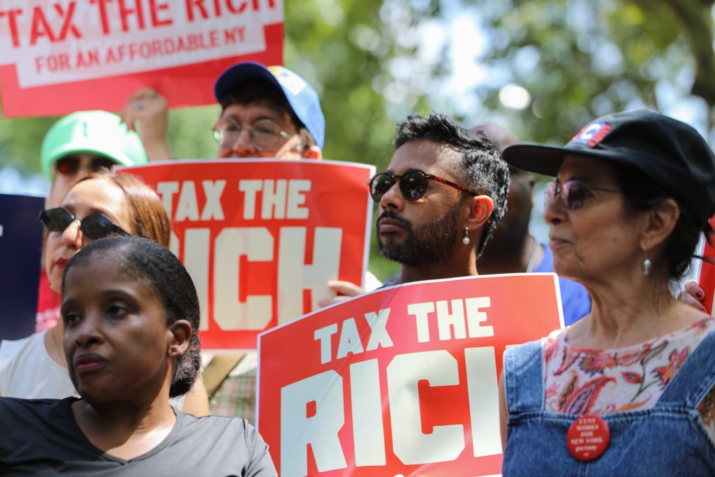 Progressive advocates rally in front of City Hall ahead of a hearing on the new pied-à-terre tax,