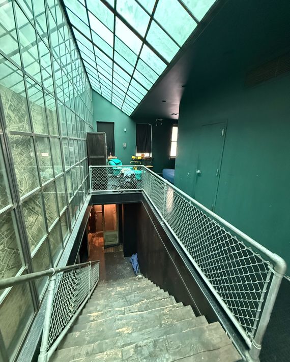 A view down the central stairs shows the library, left, and a snippet of a sleeping loft below a window in the upper right corner.