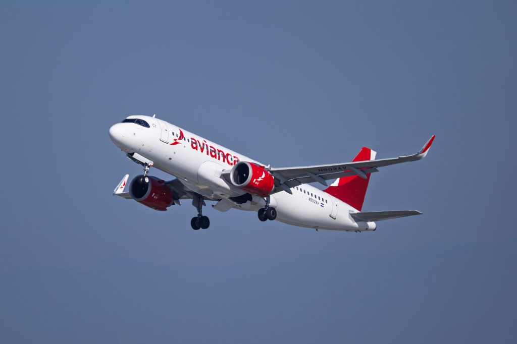 An Avianca Airlines Airbus A320Neo airplane departs against a clear sky.