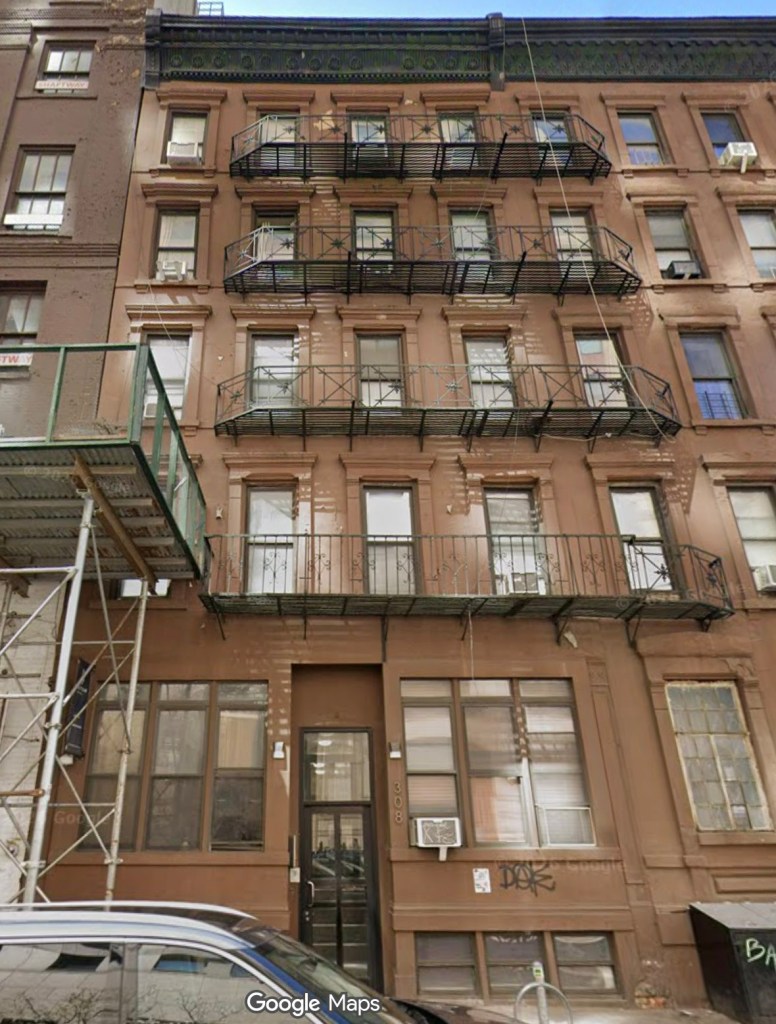 Facade of a brownstone building with fire escapes.