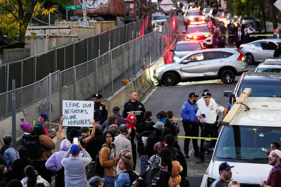 People gather at the scene of a shooting as law enforcement work the area Thursday, Oct. 8,...