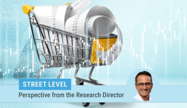 descriptive image of a toy shopping cart filled with receipts on a turquoise background. photo of research director Kartik Athreya on the bottom of the image.