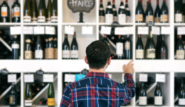 Owner/salesperson and customers inside a small, local wine shop.