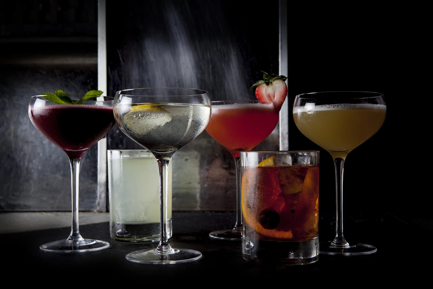 A line up of drinks against a black background