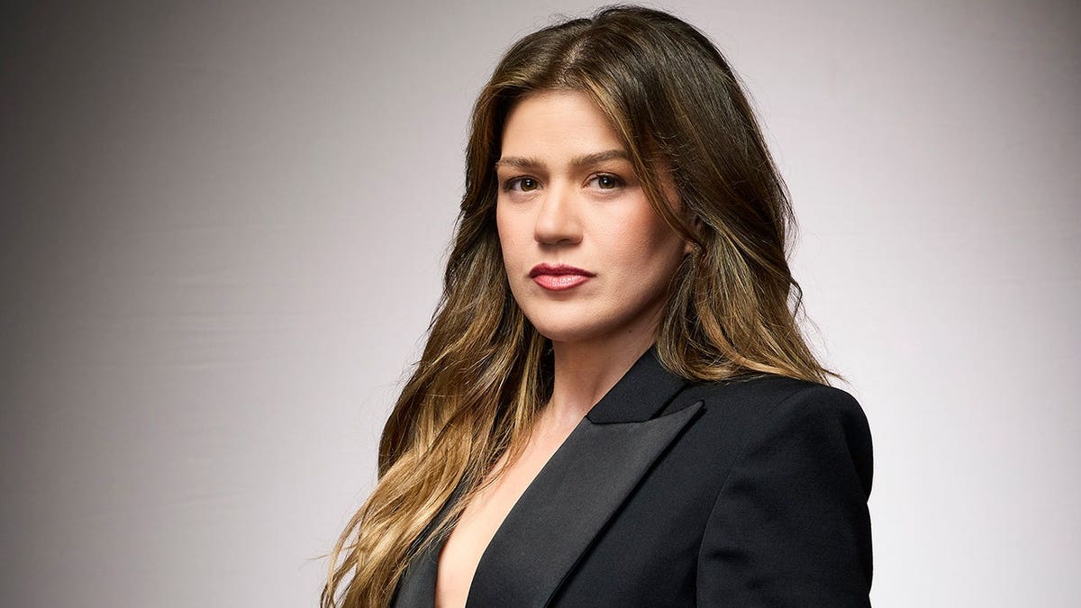 Kelly Clarkson stands on the set of The Voice.