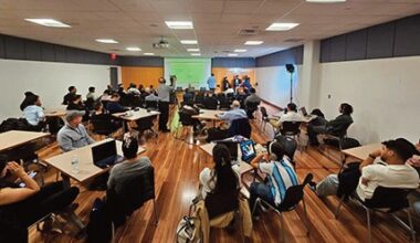Attendees listen to a presentation in the conference room.