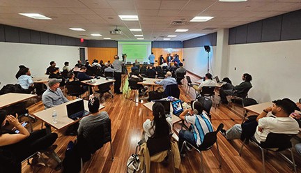 Attendees listen to a presentation in the conference room.