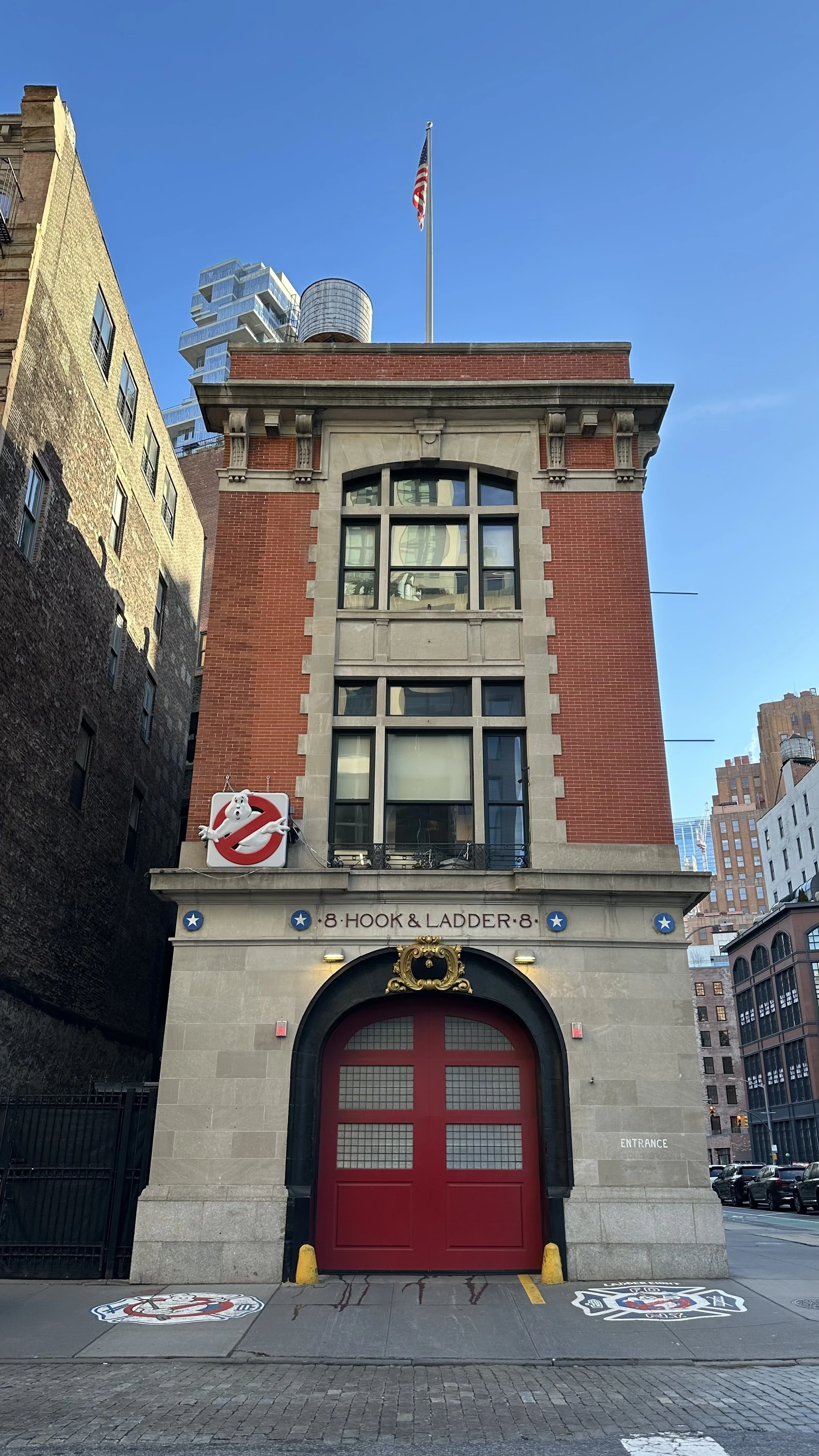 An exterior view of a firehouse with Ghosbusters signs.