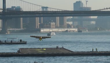 The yellow Electra EL2 Ultra Short demonstrator approaching the Downtown Skyport helipad on the East River with the Manhattan Bridge behind