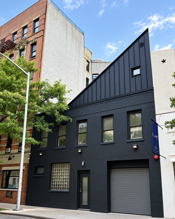 The East Village house at 406-408 East 13th Street. The pitched roof houses the upper section of his library.