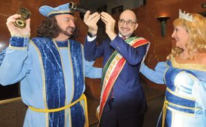 Christopher Columbus (Joe DiRico) with navigational compass in hand points out to Giuseppe Commisso the wonders of the New World seen through a telescope. Queen Isabella (Mayra DiRico) looks on approvingly.