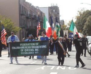The parade approaches Columbus Square on Astoria Boulevard.