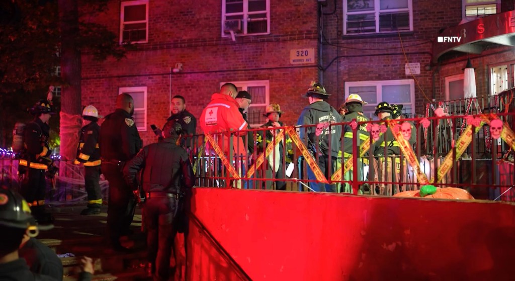 Firefighters and emergency personnel gather outside a brick building on Morris Avenue in the Bronx following a fire.