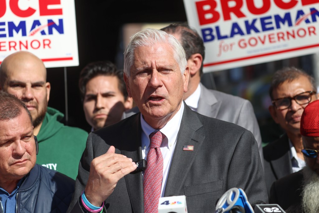Nassau County Executive and candidate for New York State Governor Bruce Blakeman speaks surrounded by supporters and campaign signs.