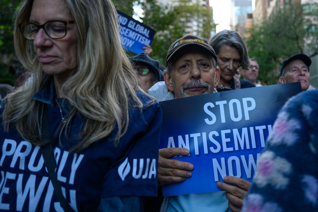 People participate in the "No More Excuses Rally Against Antisemitism" outside U.N. Headquarters in New York City, holding signs that read "Stop Antisemitism Now."