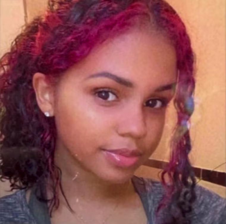 Nathaly Ramirez pictured with red hair in a ponytail, smiling at the camera