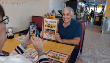 Karri Ricklin photographs Jon Ricklin holding a menu at the Falcon Diner on the Brooklawn Circle on Sept. 30.