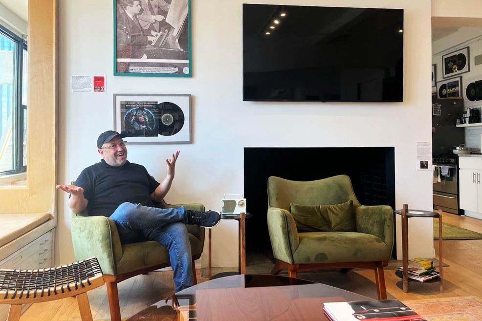 Stu Loeser in front of his office’s fireplace. You can see the same fireplace in the photo (above his head) of Leonard Bernstein and Mark Blitzstein as they discuss Blitzstein’s 'The Airborne Symphony'—for a performance that was recorded and released on an LP that also hangs on the same wall.