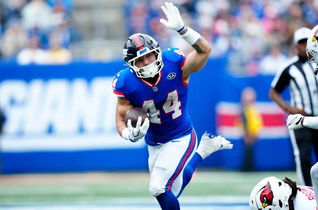 New York Giants running back Cam Skattebo (44) loses his balance while carrying the ball.