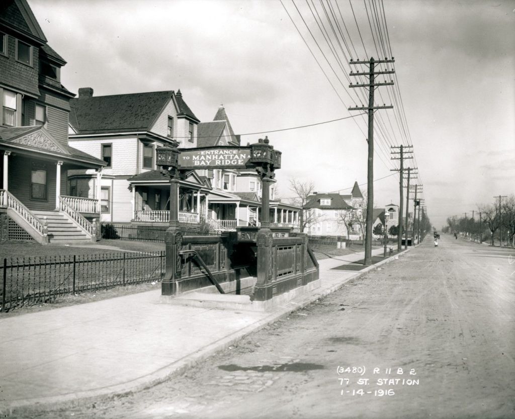 Historic photo of the entrance to the 77th Street subway station in Bay Ridge, Brooklyn, featuring ornate design elements and nearby residential homes, taken on January 14, 1916.