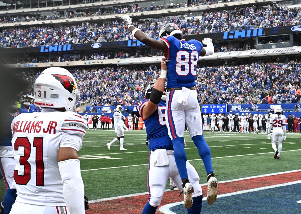 Giants wide receiver Malachi Fields (88) is lifted up by center Bryan Hudson (60) as he celebrates his touchdown during a game against the Arizona Cardinals.