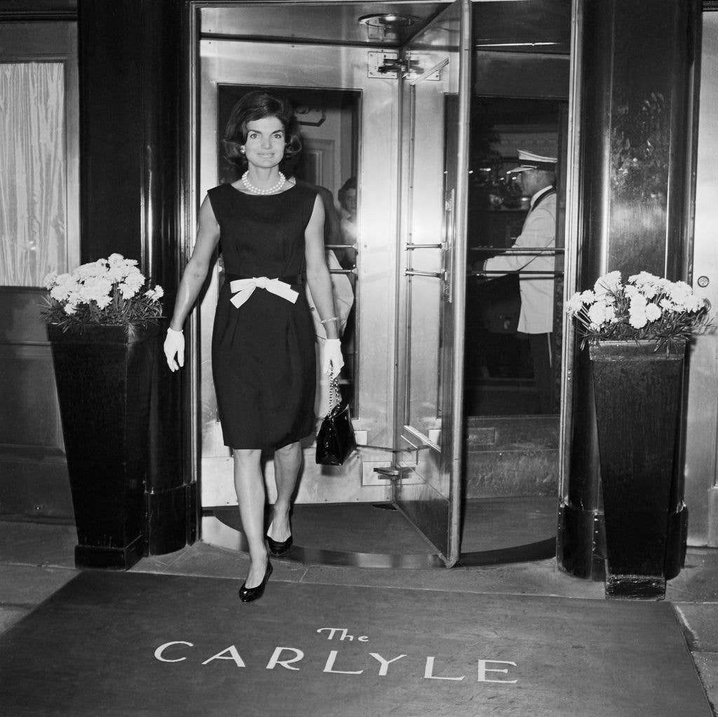 Mrs. Jacqueline Kennedy, wearing a becoming bow-at-the-waist number, leaves the Hotel Carlyle here June 8th for the hospital to visit her father-in-law, Joseph P. Kennedy, once again before returning to Washington. Jackie spent three days here. June 1962