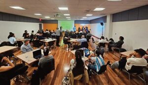 Attendees listen to a presentation in the conference room.