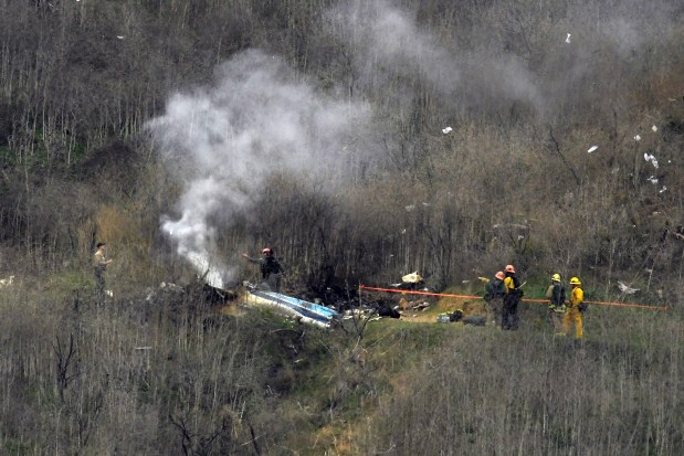 In this Jan. 26, 2020 photo, firefighters work the scene of a helicopter crash in Calabasas, Calif. The helicopter was carrying Kobe Bryant, his 13-year-old daughter and seven others. (AP Photo/Mark J. Terrill, File)