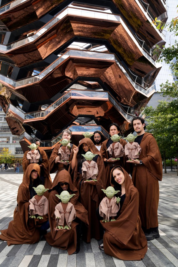 IMAGE DISTRIBUTED FOR WOW! STUFF - In this image distributed on Friday, Oct. 9 2026, Jedi-dressed demonstrators showcase WOW! Stuff's Yoda Puppetronic by RealFX in front of the iconic Vessel at Hudson Yards during New York Comic Con in New York. Bringing the magic of "Star Wars" beyond the convention floor, the interactive Puppetronic features lifelike movements and more than 120 sounds and actions, creating memorable moments for fans throughout New York City. (Charles Sykes/AP Content Services for WOW! Stuff)