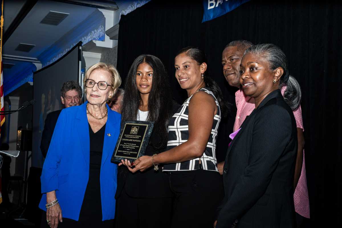 Dr. Sandra Kase presents Crismarie Santana with the award for Best 7th-Grade Advocate of the 28th Thurgood Marshall Mock Trial Competition.