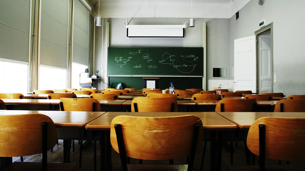 A large, empty classroom, lit by morning light