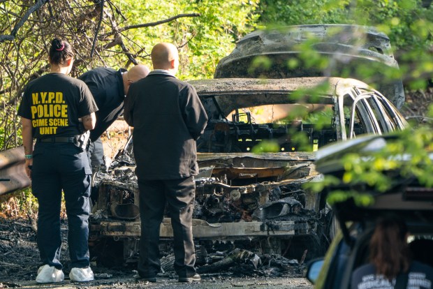 Police investigate after the bodies of Jesse Parrilla and Nikki Huang were found inside a car on fire on Shore Road near Pelham Split Rock Golf Course in Pelham Bay Park in the Bronx on Monday, May 16, 2022. (Theodore Parisienne for New York Daily News)