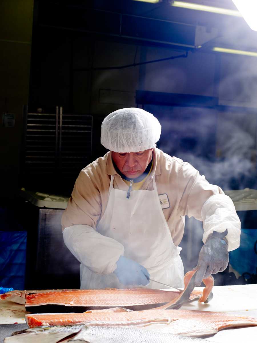 person working cold smoking fish