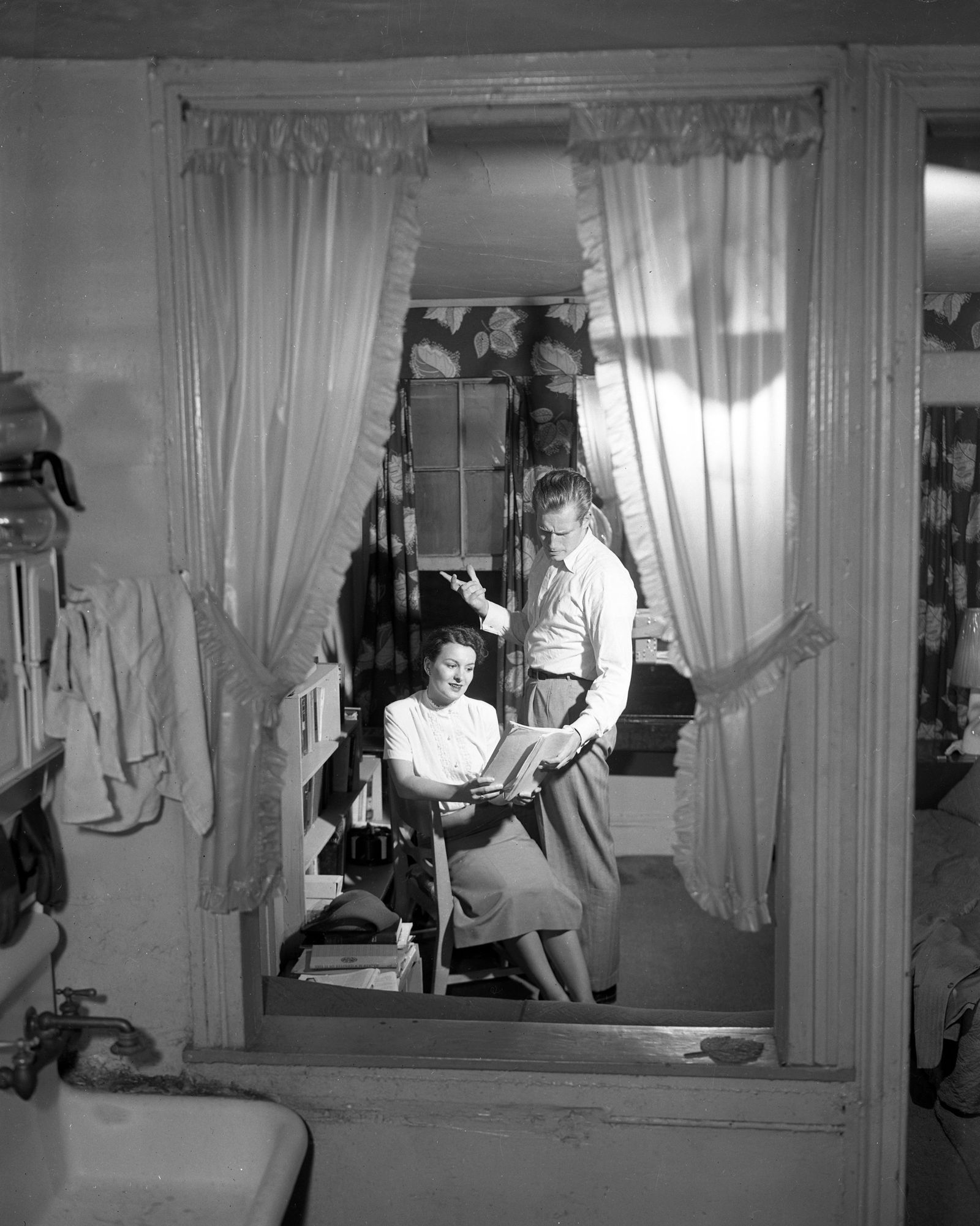 blackandwhite photo of Charlton Heston right and Lydia Clarke Heston as seen through window frame in their Hells Kitchen...