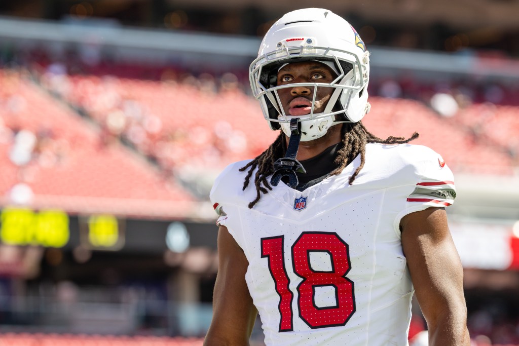 Arizona Cardinals player wearing a white jersey with the number 18 and a white helmet during a game.