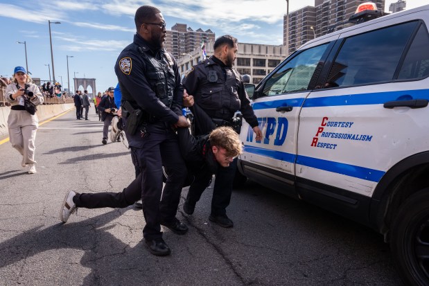 A protestor is carried as they are detained by NYPD officers for blocking the Brooklyn Bridge as they demonstrate for Oscar Belgal, who was shot by ICE, on Oct. 28, 2026, in New York City. (Photo by Adam Gray/Getty Images)
