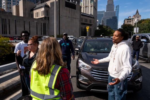 Motorists argue with protestors as they block the Brooklyn Bridge in support of Oscar Belgal, who was shot by ICE, on Oct. 28, 2026, in New York City. (Photo by Adam Gray/Getty Images)