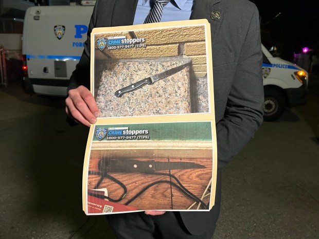 Police holding photos of the knives at the scene of the police involved shooting. One woman shot by police and three stabbed inside a single family home on 149 St in Queens on Oct. 23, 2026. (Kerry Burke/New York Daily News)