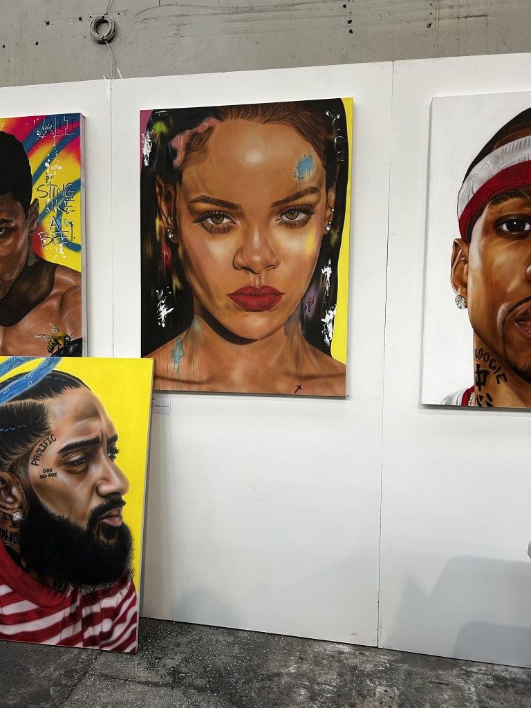 Colorful portrait paintings of prominent figures in music and entertainment are displayed at CultureCon 2026 at the Brooklyn Navy Yard in Brooklyn, New York. Photo by Catherine Roth / The Haitian Times
