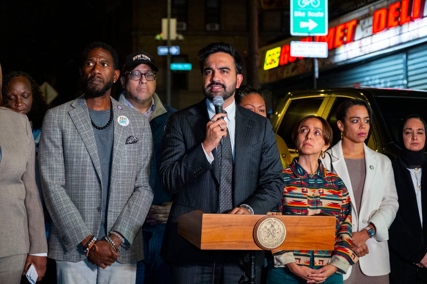 Mayor Zohran Mamdani of New York, center, spoke to reporters from the scene where a federal immigration agent shot and wounded a man in a largely residential section of New York City, Thursday.