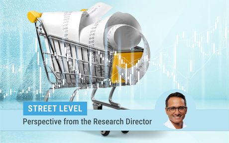 descriptive image of a toy shopping cart filled with receipts on a turquoise background. photo of research director Kartik Athreya on the bottom of the image.