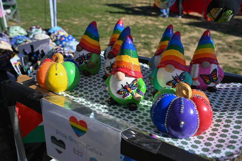 yard gnomes with rainbow hats sit atop a vendor table