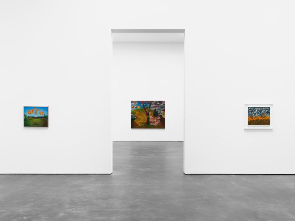 A minimalist gallery installation features three colorful landscape paintings displayed across white walls, with a central work visible through a rectangular doorway.