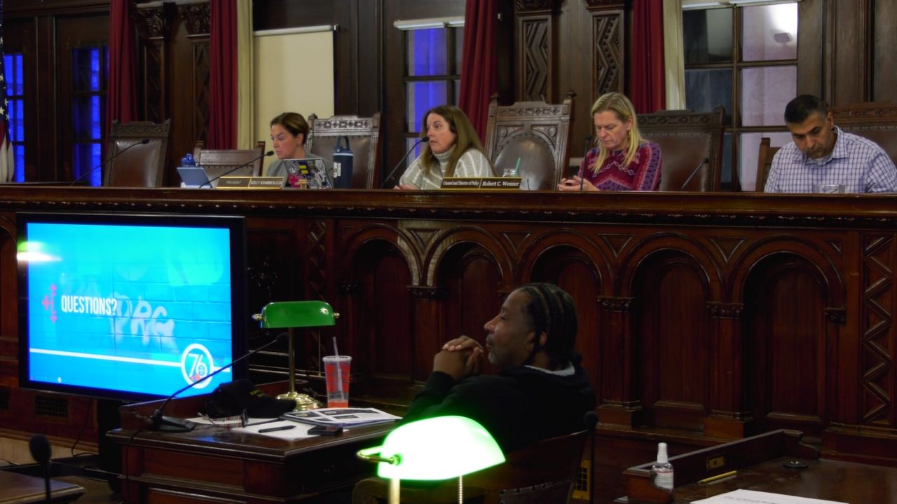 Four people sit in council meeting