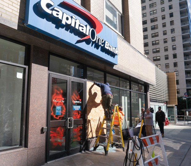 Vandalized doors and windows of a Capital One branch on E. 86th St. and Second Ave. are pictured Monday.