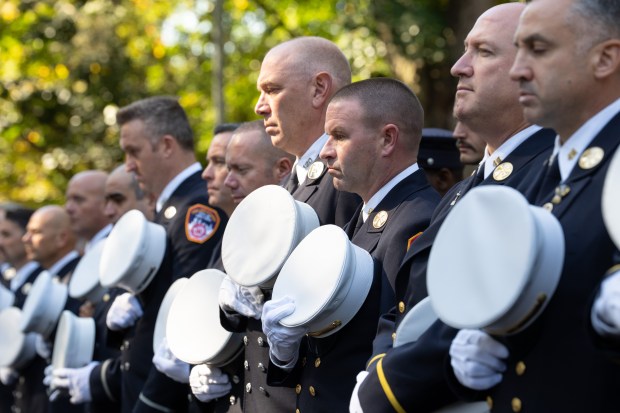 FDNY members rest their hats over their hearts in respect for fallen members during FDNY Annual Memorial Service at the Fireman's Monument Wednesday, October, 7, 2026 in Manhattan, New York. (Barry Williams/ New York Daily News)