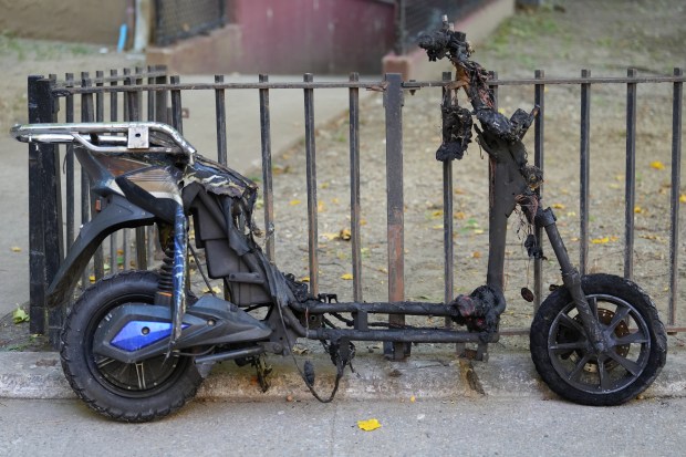 A burned e-bike is pictured after a deadly lithium-ion battery fire caused by an e-bike in an 11th-floor apartment in the Patterson Houses on Morris Ave. near E. 140th St. in the Bronx early Wednesday, Oct. 28, 2026. 